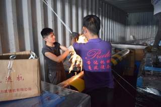 Workers securing equipment inside shipping container